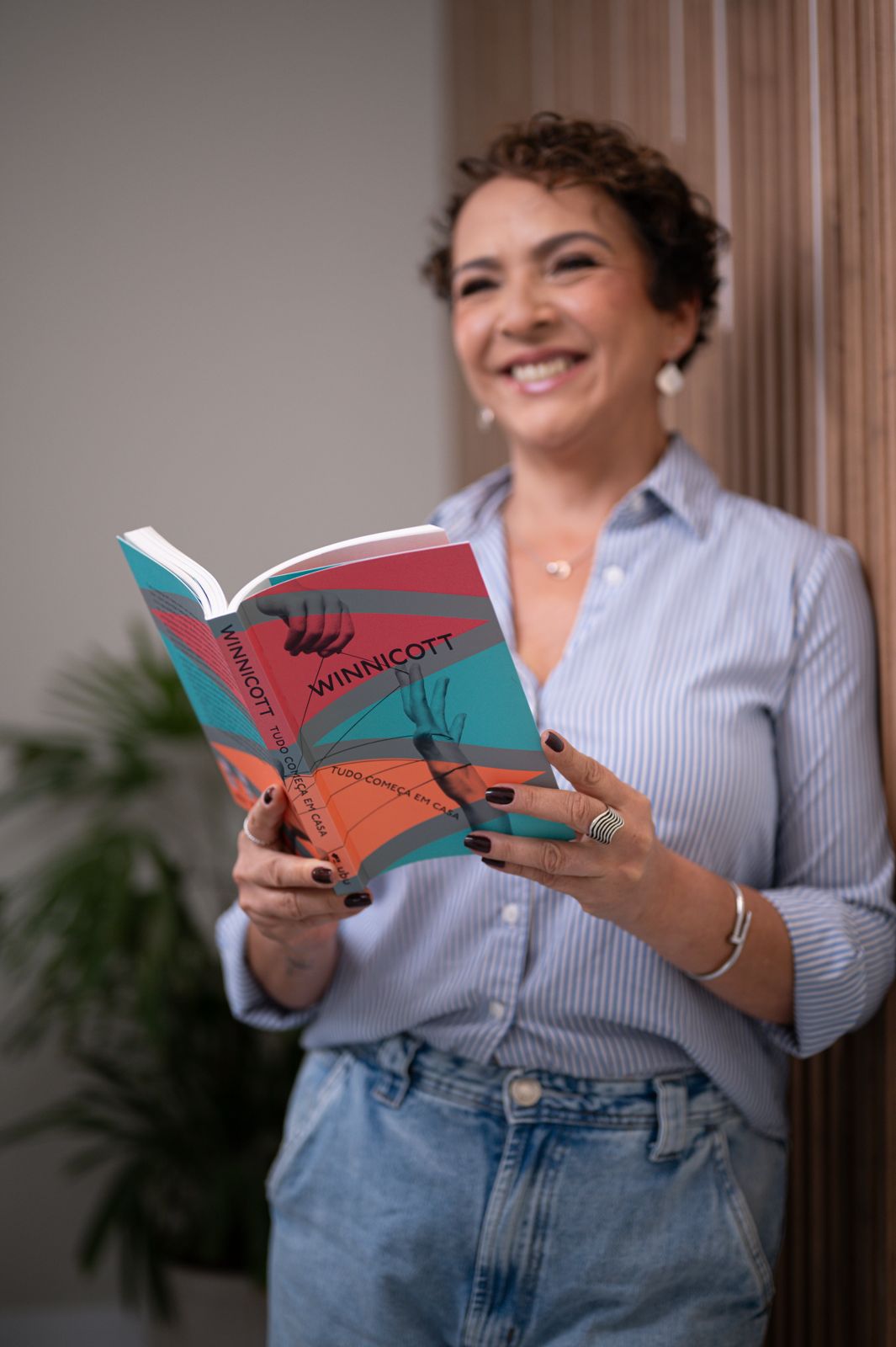 Patrícia Sena segurando livro de Winnicott, demonstrando seu embasamento teórico em psicopedagogia